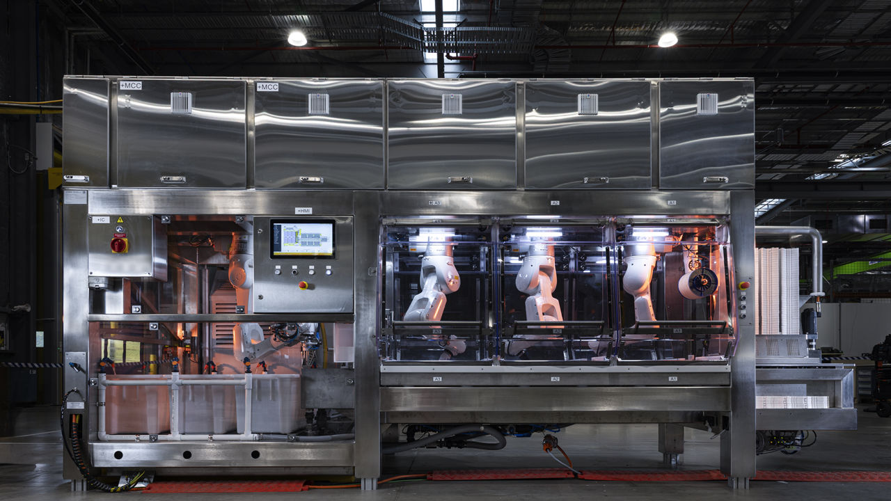 Machine One: a semi-automated coral-seeding system is a large metallic machine with various robotic arms. 