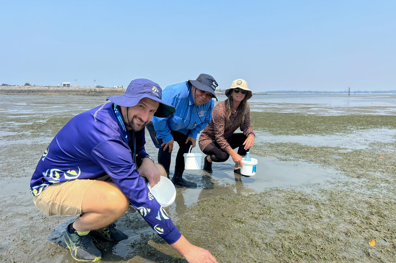 Markeeta teaching volunteers how to pick seagrass flowers for the nursery.