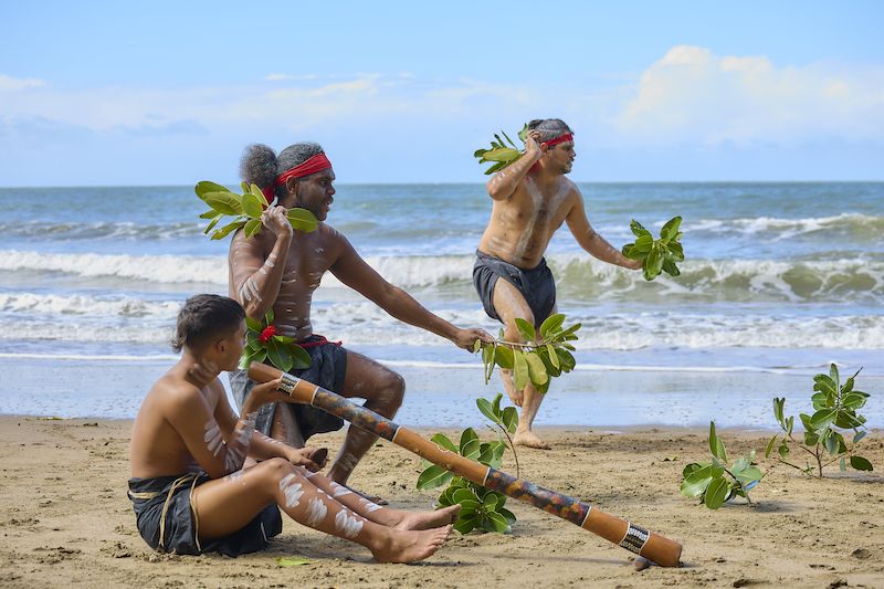 Goondoi Rangers Mitchell Purcell, Magnus Edwards and Jordan Rudkin perform Traditional dancing at Etty Bay Beach. Credit: Our Reef Stories.