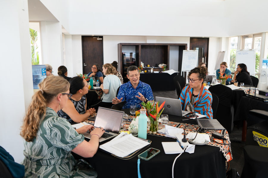Three participants in a workshop discussion seated at a table.