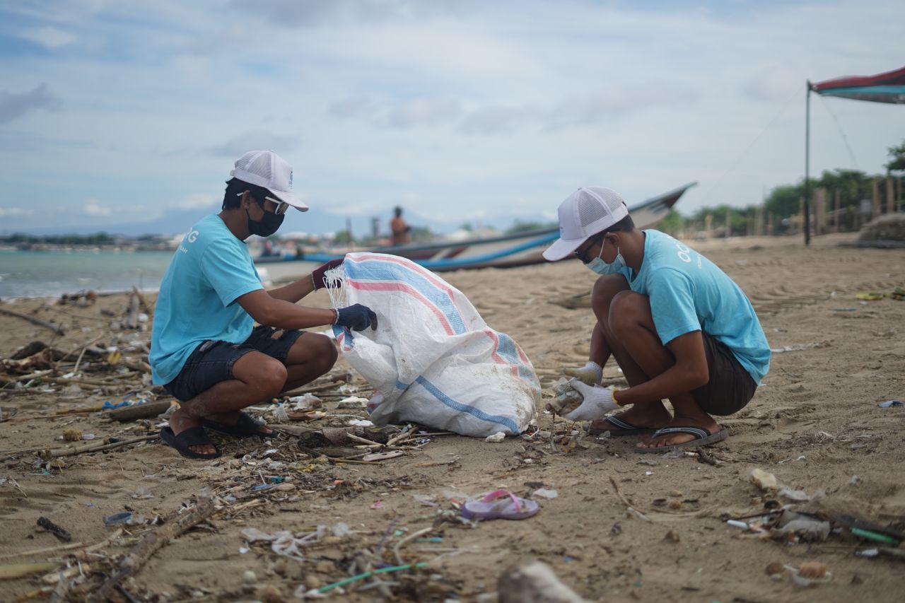 Two volunteers clean the beach in Indonesia. Credit: Ocean Cleanup Group 